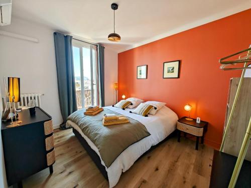 - une chambre avec un mur orange, un lit et une fenêtre dans l'établissement Cozy roof terrace near Promenade des Anglais - AC, à Nice