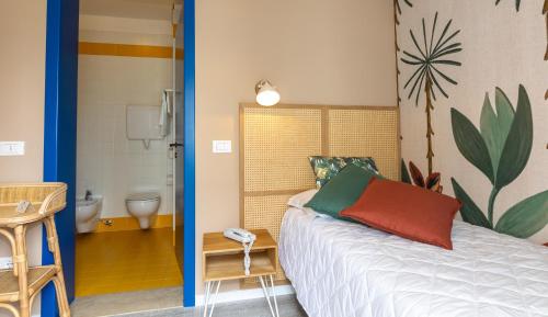 a bedroom with a bed and a bathroom with a toilet at Hotel Wally in Lido di Jesolo