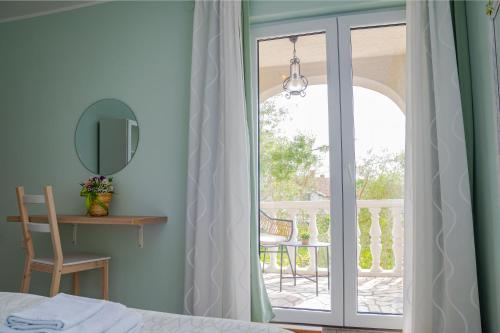 a bedroom with a door leading to a balcony at Apartman Doris in Milohnići