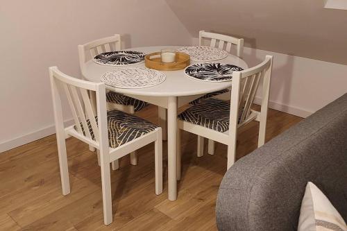 - une table blanche avec 4 chaises et un bol dans l'établissement Sous les toits de Béthune, à Béthune