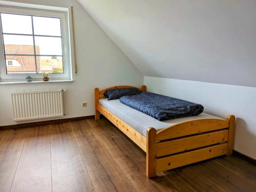 1 dormitorio con cama de madera y ventana en Idyllisches Zuhause nahe Verden en Dörverden