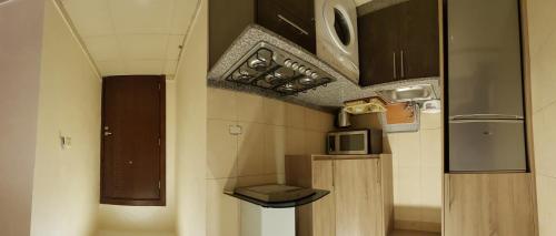 a small kitchen with a microwave and a stove at Marmaris Hotel Apartments in Amman