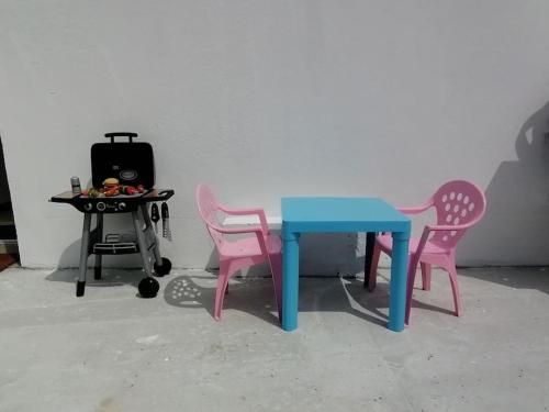 einen Tisch mit 2 Stühlen und einen Tisch mit einem Herd in der Unterkunft Maison centre bourg, 6 pers, 5 minutes de la plage in Plomeur