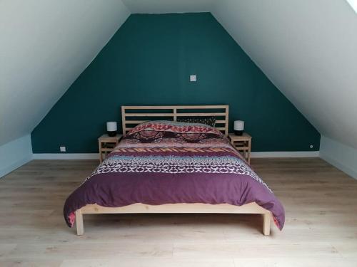 ein Schlafzimmer mit einem Bett mit einer grünen Wand in der Unterkunft Maison centre bourg, 6 pers, 5 minutes de la plage in Plomeur