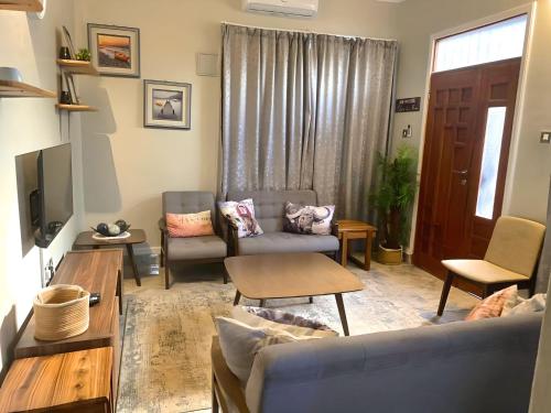 uma sala de estar com dois sofás e uma televisão em Tulivu House -2bedroom vacation home close to the beach em Dar es Salaam
