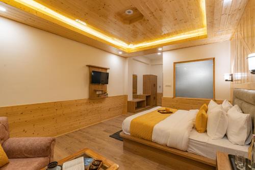 a hotel room with a bed and a flat screen tv at The Social Stays Manali formerly ArtBuzz in Manāli