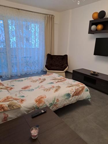 a bedroom with a bed and a chair and a table at Happy Rental Apartments 1 in Craiova