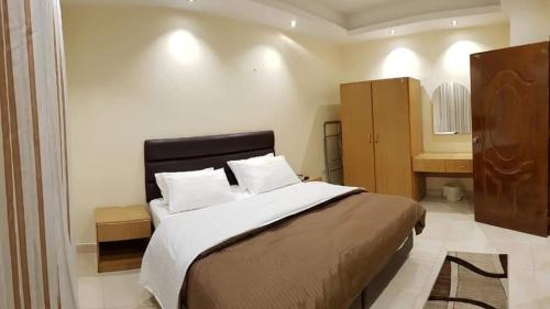 アンマンにあるMarmaris Hotel Apartmentsの大きなベッドとバスルームのある寝室