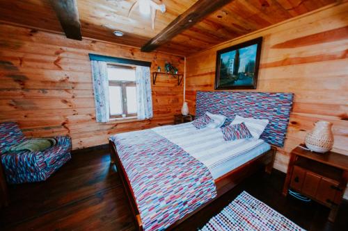 een slaapkamer met een bed in een blokhut bij Domek w lesie, nocleg na Lubelszczyźnie in Sosnówka