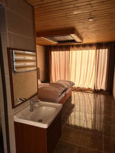 a bathroom with a sink and a bed in a room at Full moon camp in Disah