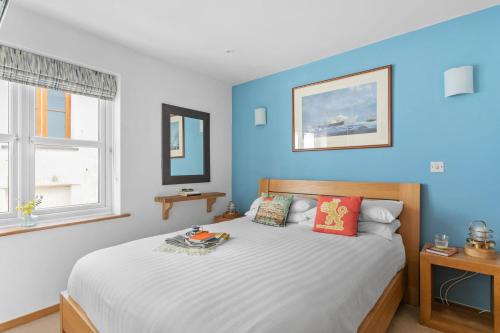 a bedroom with a large bed with blue walls at White Star, Brixham in Brixham