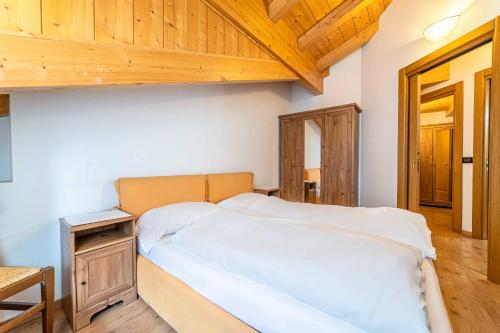 a bedroom with a bed and a wooden ceiling at Appartamento Dolomiti Alleghe in Alleghe