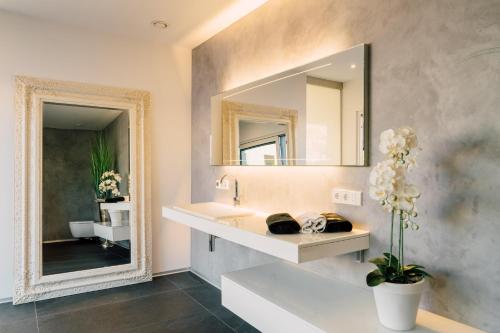 a bathroom with a sink and a mirror at Traumblick trifft Luxus! in Weitersburg