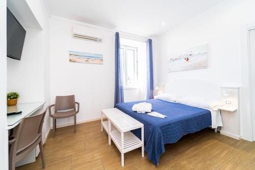 um pequeno quarto com uma cama, uma mesa e cadeiras em FRENNESIA Amalfi Coast em Atrani