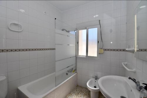 y baño con bañera, lavabo y aseo. en Chalet La Alberca, en Chiclana de la Frontera