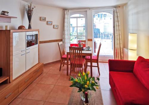 een woonkamer met een rode bank en een tafel bij Haus Meeresblick - Ferienwohnung Strandnah A 1.07 (Ref. 128675) in Baabe