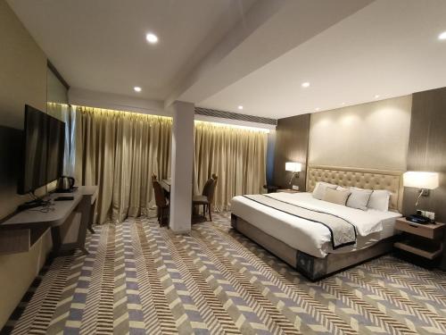 a hotel room with a bed and a television at Hotel Highway Inn Andheri East in Mumbai