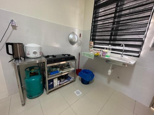 uma pequena cozinha com um lavatório e um fogão em Fiyyadh Homestay Gambang em Gambang