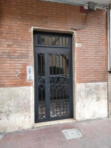 a door with a iron gate in a brick wall at Casa al mare in Anzio