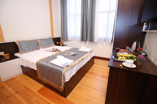 um quarto de hotel com uma cama e uma mesa com comida em Grand almira hotel em Istambul