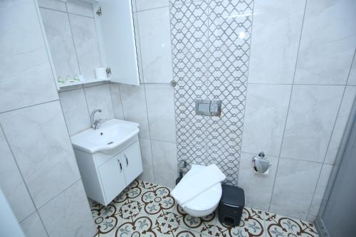 uma casa de banho branca com um WC e um lavatório em Grand almira hotel em Istambul