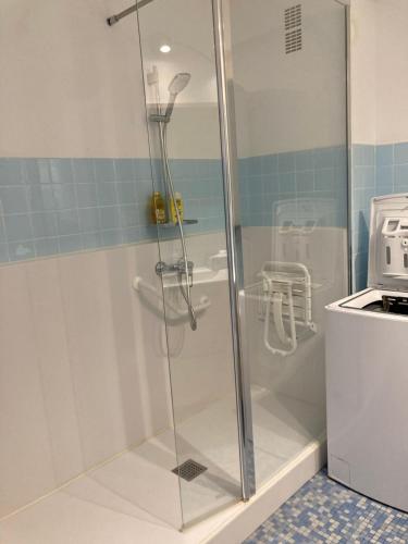 une douche avec une porte vitrée dans une salle de bain dans l'établissement Au cœur de Cavalaire sur mer, à Cavalaire-sur-Mer