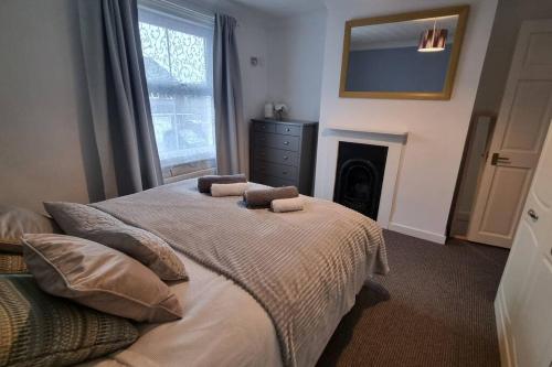 a bedroom with a bed with two pillows and a fireplace at Entire House With Garden & Parking Nr Ashford Int in Ashford