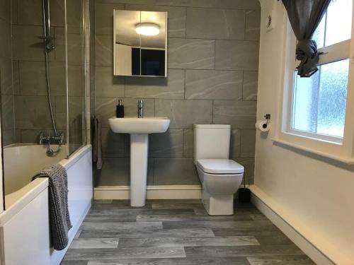 ein Badezimmer mit einem Waschbecken, einem WC und einer Badewanne in der Unterkunft Entire House With Garden & Parking Nr Ashford Int in Ashford