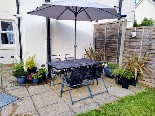 a black table with two chairs and an umbrella at Entire House With Garden & Parking Nr Ashford Int in Ashford