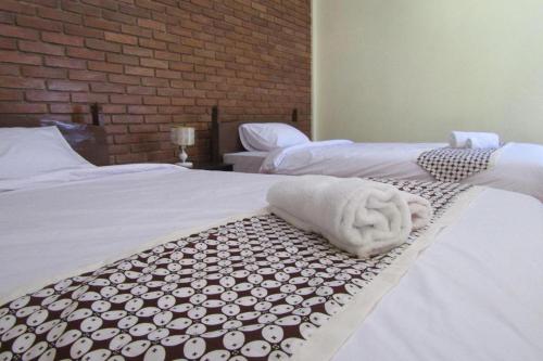 a room with two beds with white towels on them at Omah Rohadi Syariah by Ndalem Beong in Borobudur
