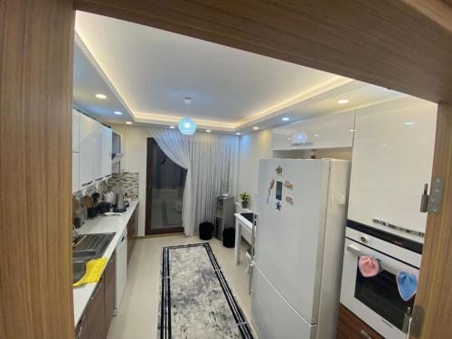 eine Küche mit einem weißen Kühlschrank und einer Spüle in der Unterkunft Lüx daire in Pelitli