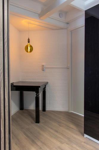 a room with a black table and a light at Bed and Breakfast Harvey room in Delden