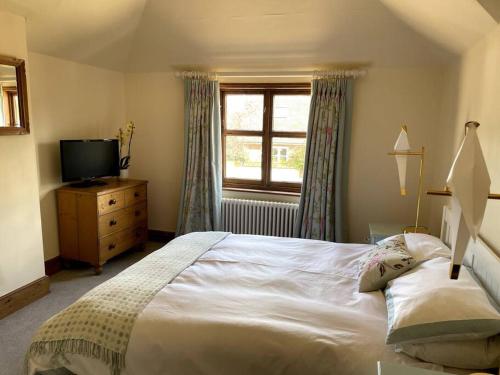 - une chambre avec un grand lit blanc et une télévision dans l'établissement Bear House - East wing, à Nayland