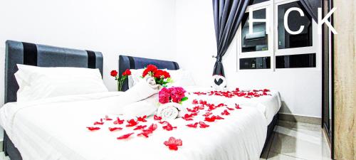 吉隆坡Titiwangsa Core at TR Residence by HCK的一张白色的床,上面有红色的鲜花