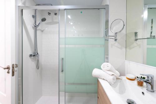 a bathroom with a glass shower and a sink at Genteel Home Victoria in Cádiz