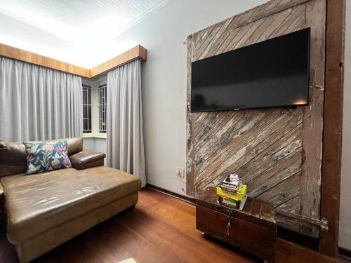 a living room with a couch and a television on a wall at Seaview Family Cottage in Swakopmund