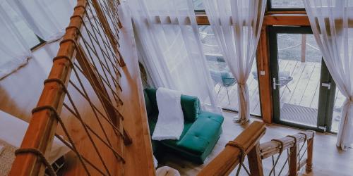 a room with a green chair in front of a window at Stuf by NorAtlas Heritage - Adults Only in Buzău