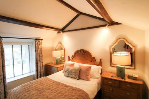 sypialnia z dużym łóżkiem i lustrem w obiekcie Kirkstone Cottage ideal for a romantic break centrally located in Ambleside w mieście Ambleside