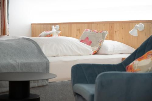 a bedroom with a bed and a couch and a chair at Santner, Hotel in Eugendorf