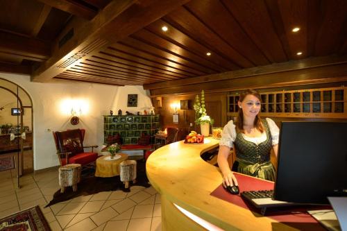 a woman sitting at a desk with a computer at Santner, Hotel in Eugendorf