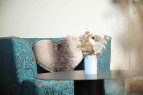 a blue couch with a vase of flowers on a table at Santner, Hotel in Eugendorf
