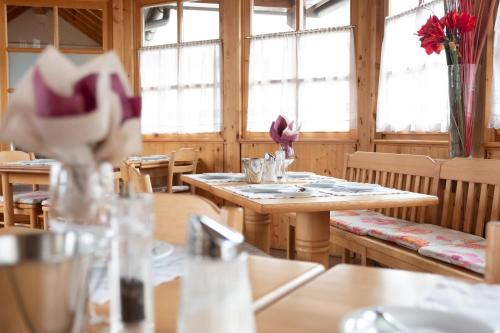 a dining room with tables and chairs and windows at Santner, Hotel in Eugendorf