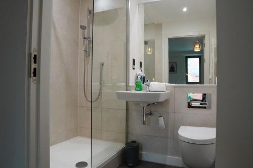 y baño con ducha, lavabo y aseo. en Luxury Townhouse In Central Manchester, en Mánchester
