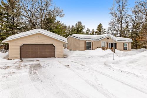 una casa con un garaje en la nieve en Serendipitime, en Boulder Junction