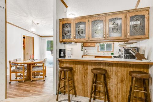 Una cocina con gabinetes de madera y un mostrador con taburetes. en Serendipitime, en Boulder Junction