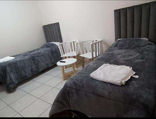 1 dormitorio con 2 camas, sillas y mesa en YUJUY APARTAMENTO en San Salvador de Jujuy