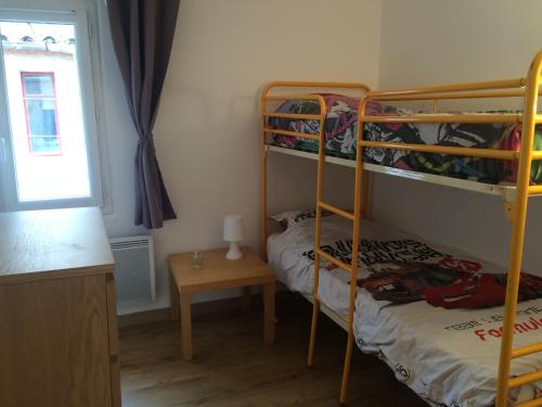 une chambre avec deux lits superposés et une table dans l'établissement T4 - climatisé avec toit terrasse - 300m des plages, à La Ciotat