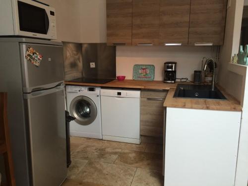 une cuisine avec un réfrigérateur et une machine à laver dans l'établissement T4 - climatisé avec toit terrasse - 300m des plages, à La Ciotat