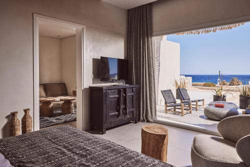 a bedroom with a bed and a television and a patio at Serenity Suite Milos in Mandrakia