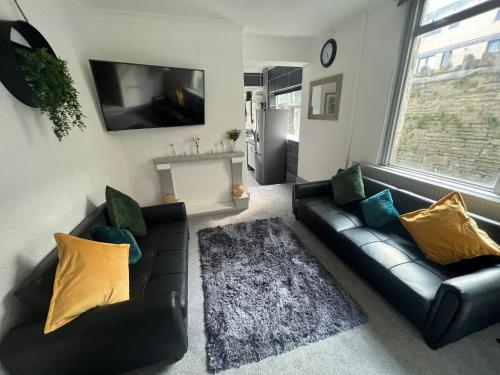 a living room with two leather couches and a television at 4 Bed House! 10%OFF! Groups, Contractors! 9 Guests - Garden - Free On street Parking in Cardiff